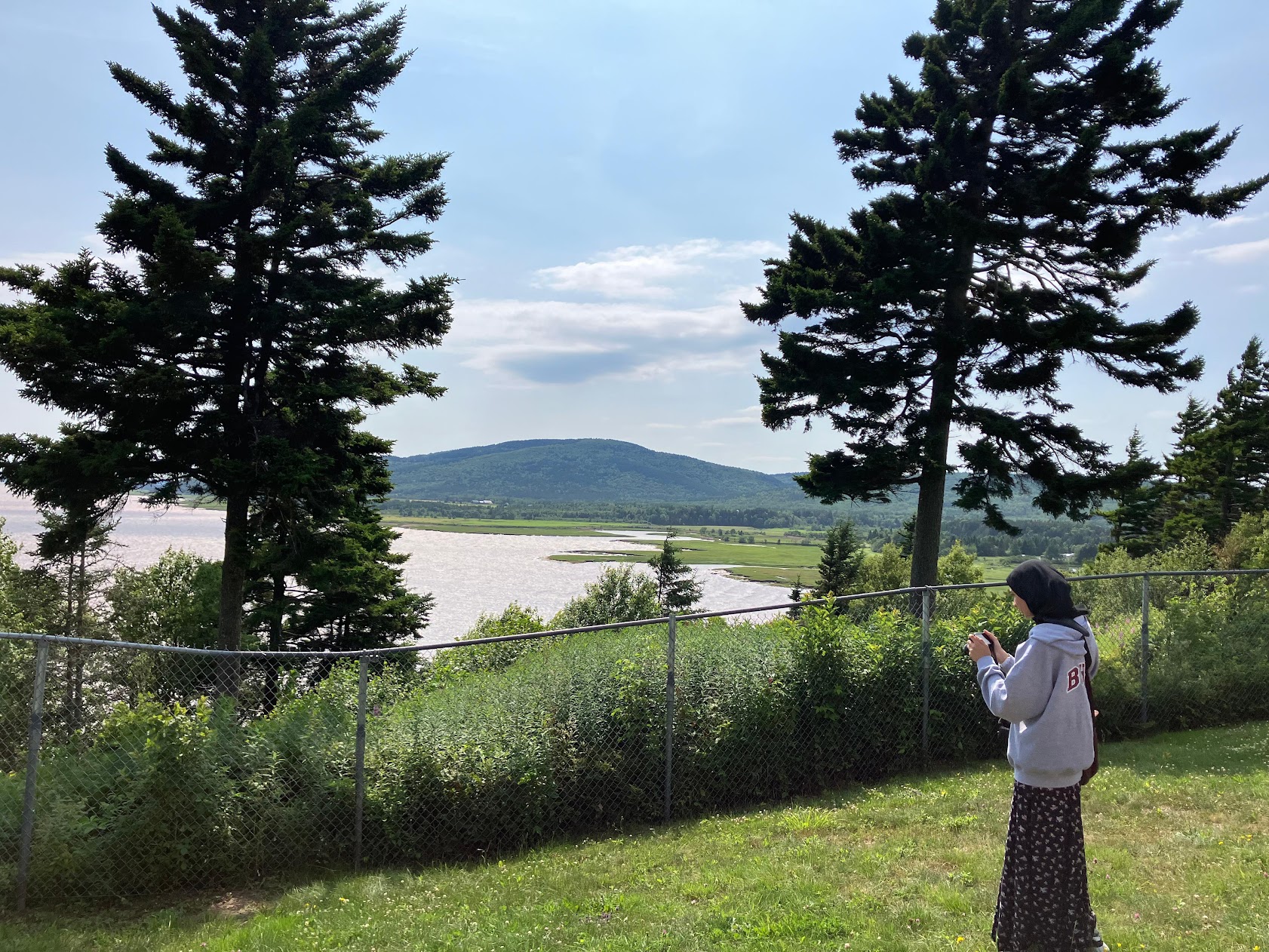 girl holding camera to take pictures at hopewell rock national park